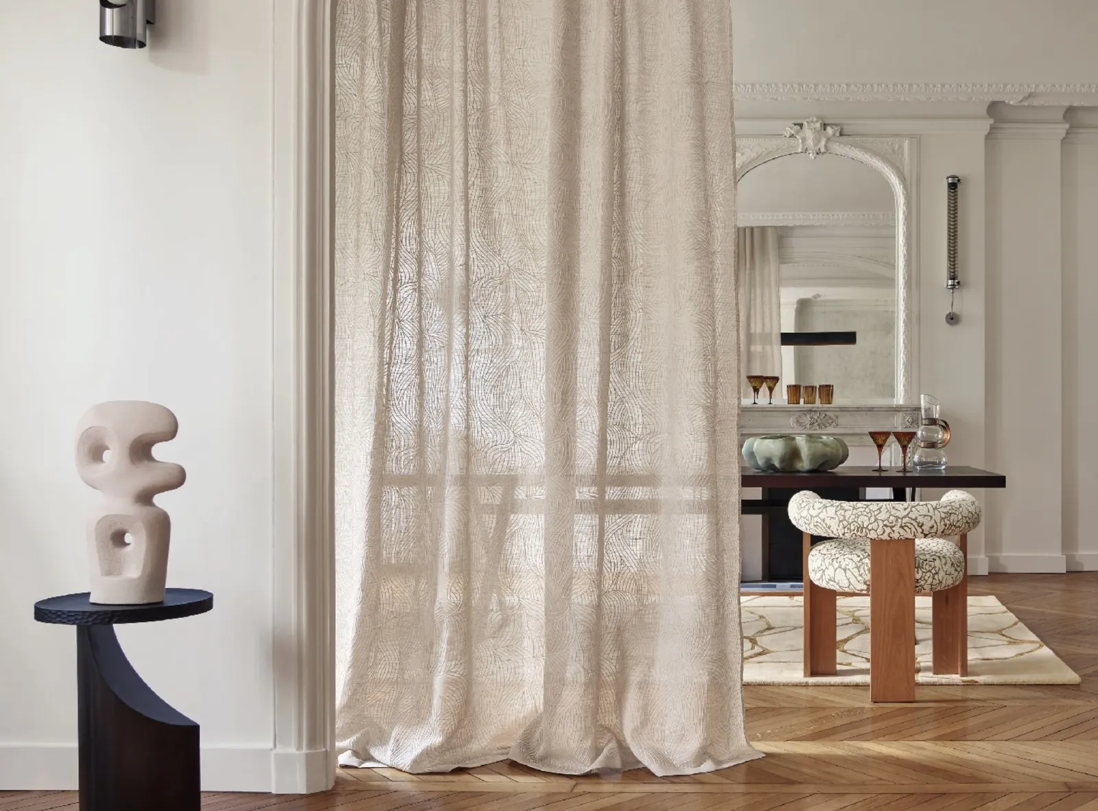 Sheer linen curtain in a dining room with a sculptural side table