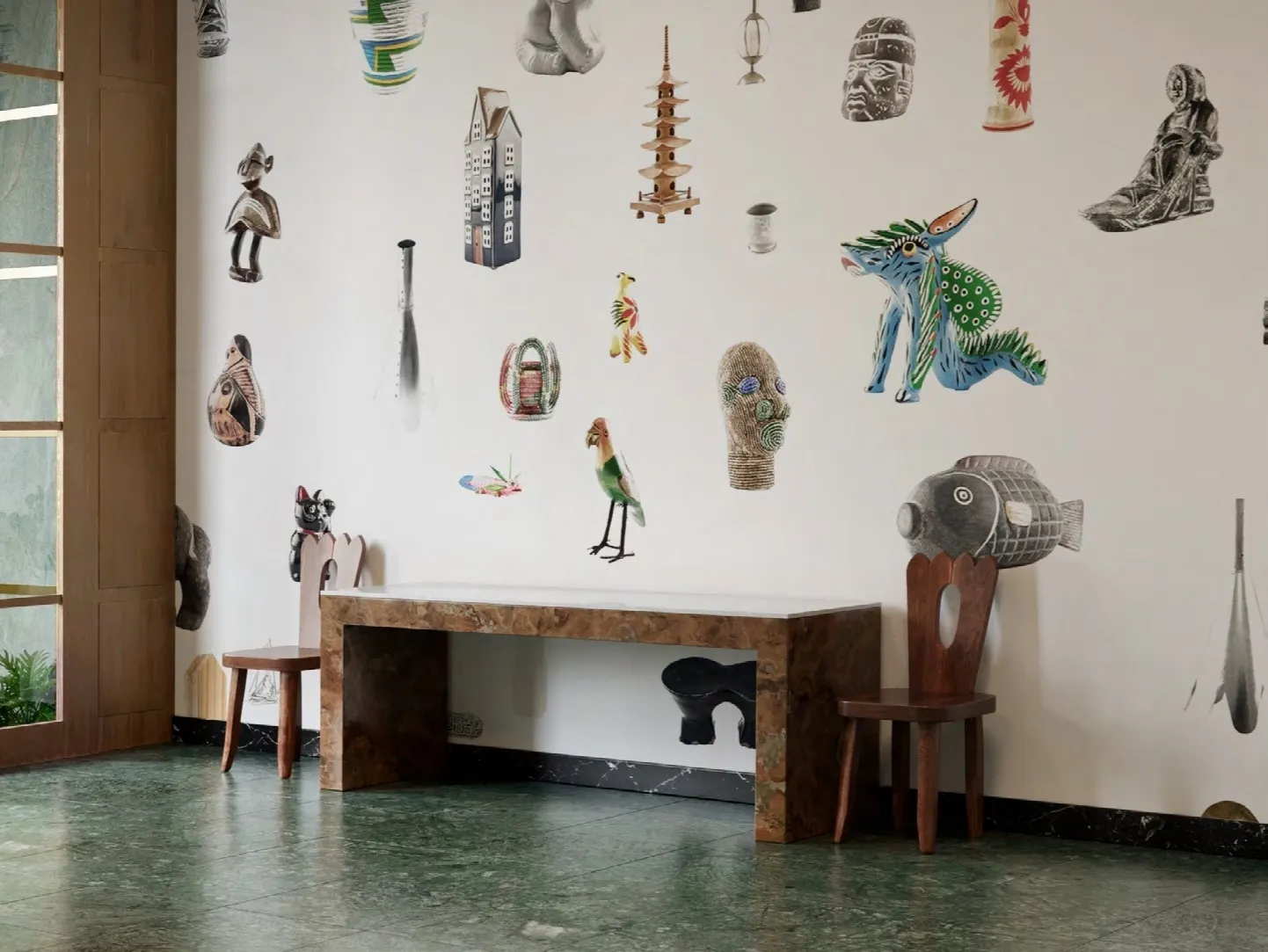 Folk art objects arranged across a white wall above a stone console