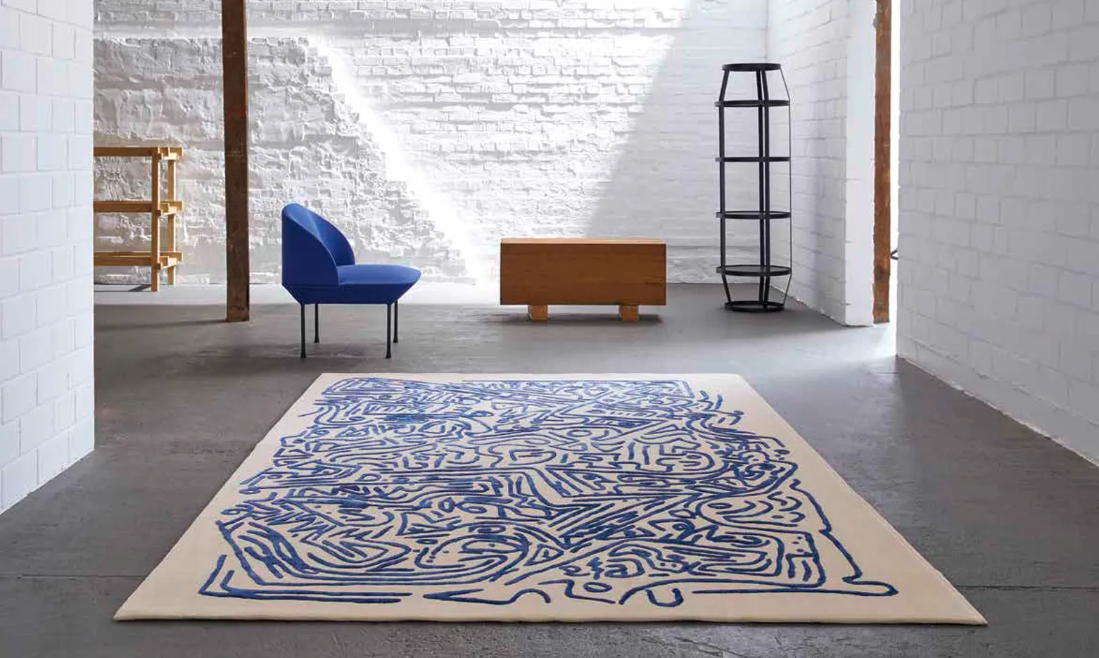 Blue and cream abstract rug in a white brick room